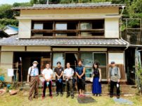 H&C財団の視察団と空き家物件の前で記念撮影