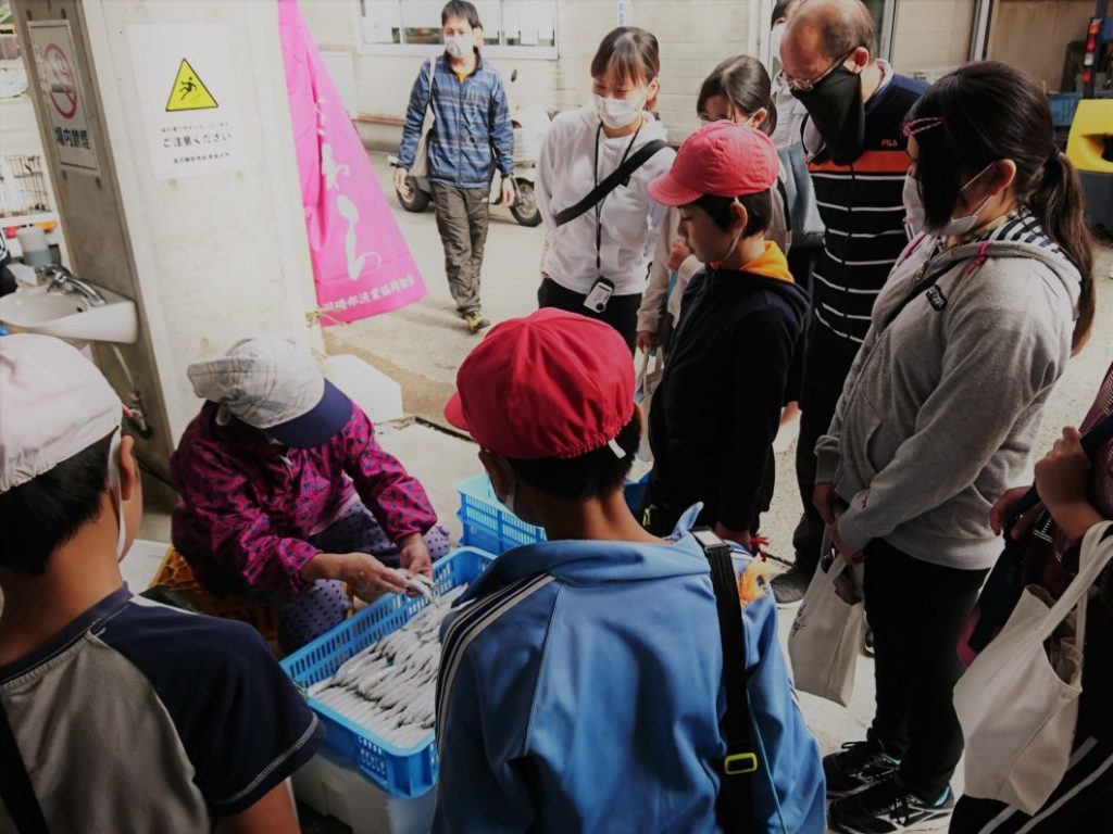 漁協の市場を見学する児童たち