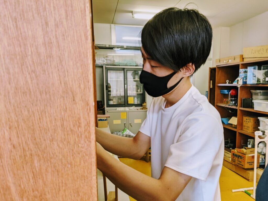 菅島小学校の理科準備室で器具を確認する横尾氏