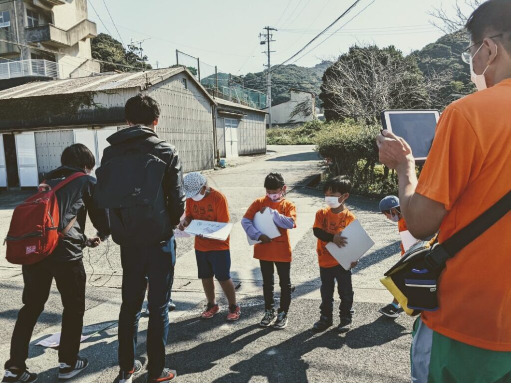 公園の前でクイズの準備をする島っ子ガイド児童