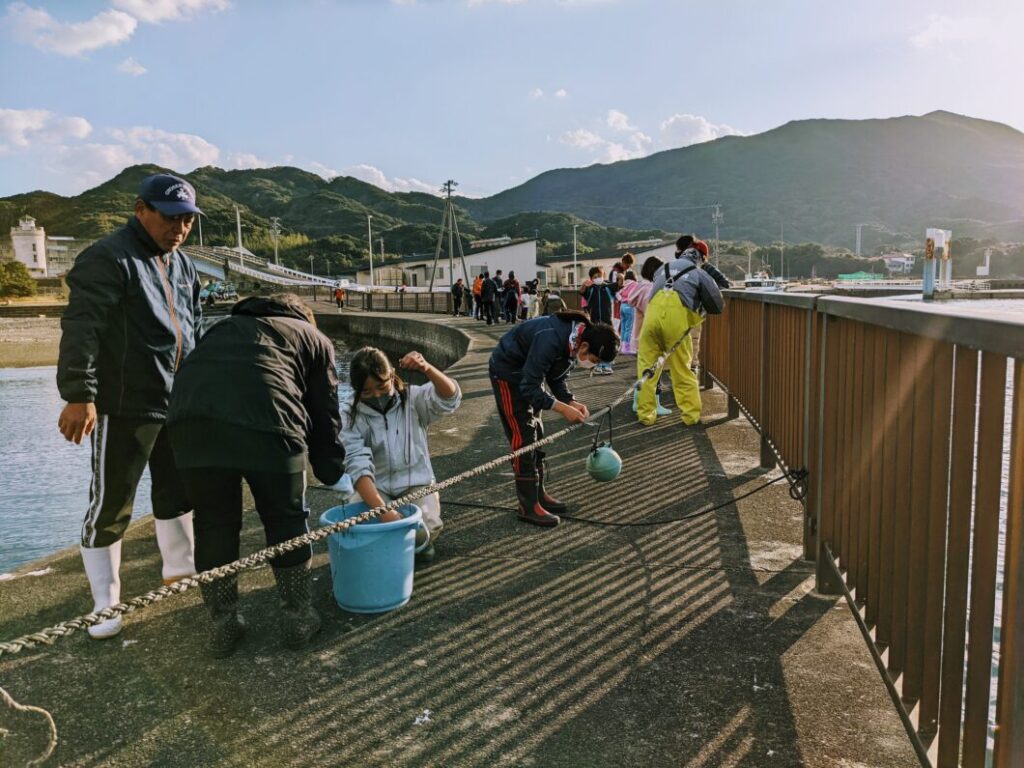 ロープにわかめの種糸をまきつける菅島小学校児童たち